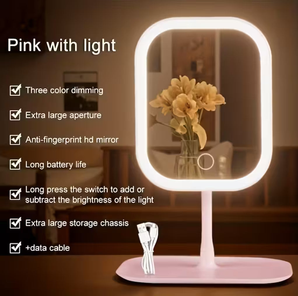 Pink LED makeup mirror with warm lighting displayed in a lifestyle setting, with feature callouts including three colour dimming, anti-fingerprint HD mirror, long battery life, and extra large storage chassis