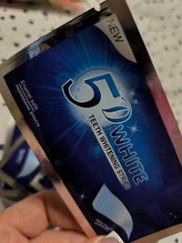 Customer holding a packet of 5D White Teeth Whitening Strips - enamel safe with professional effects