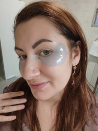 Woman wearing translucent blue under-eye patches, viewed from the side